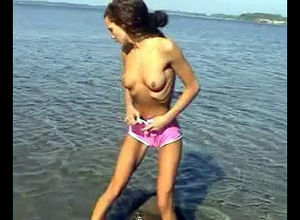 Tanned, bare young drizzling in the sea